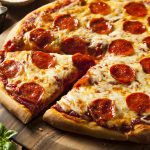 Photo of pepperoni pizza with slice cut