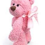 Photo of pink teddy bear with ribbon tied in bow