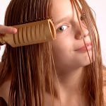 Photo of child brushing wet hair