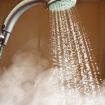 Photo of shower head with running hot water
