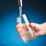 Photo of person filling glass with water