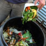 Photo of person adding compost to bin