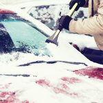 Photo of person scraping snow off car