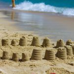 Photo of small sand castles in circle on beach