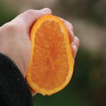 Photo of hand squeezing orange