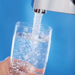 Photo of person filling glass with water