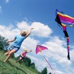 Photo of two children flying kites
